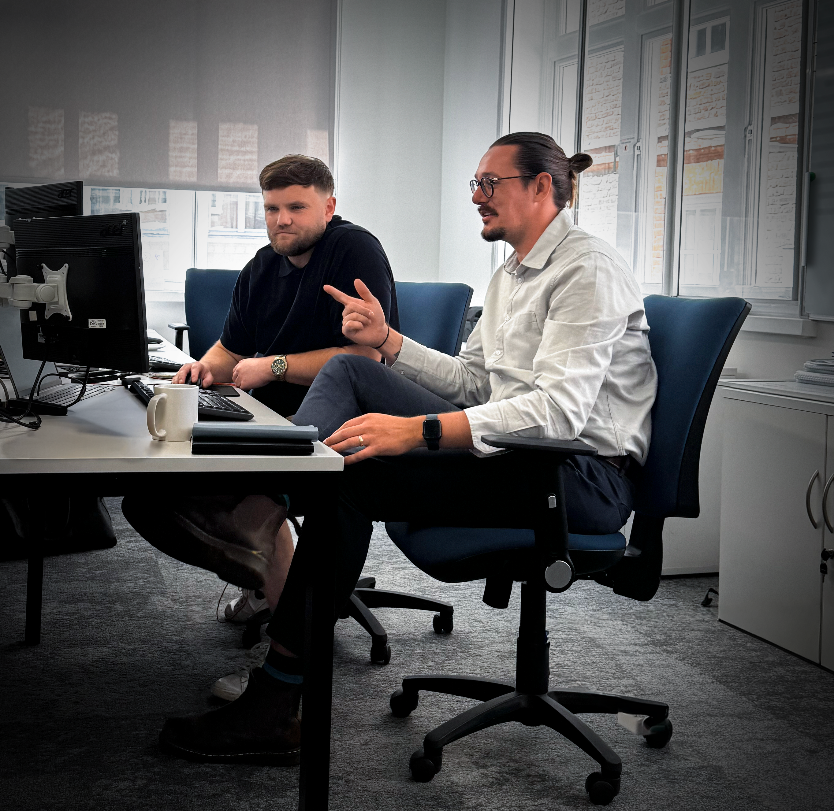 two office workers smiling at laptop